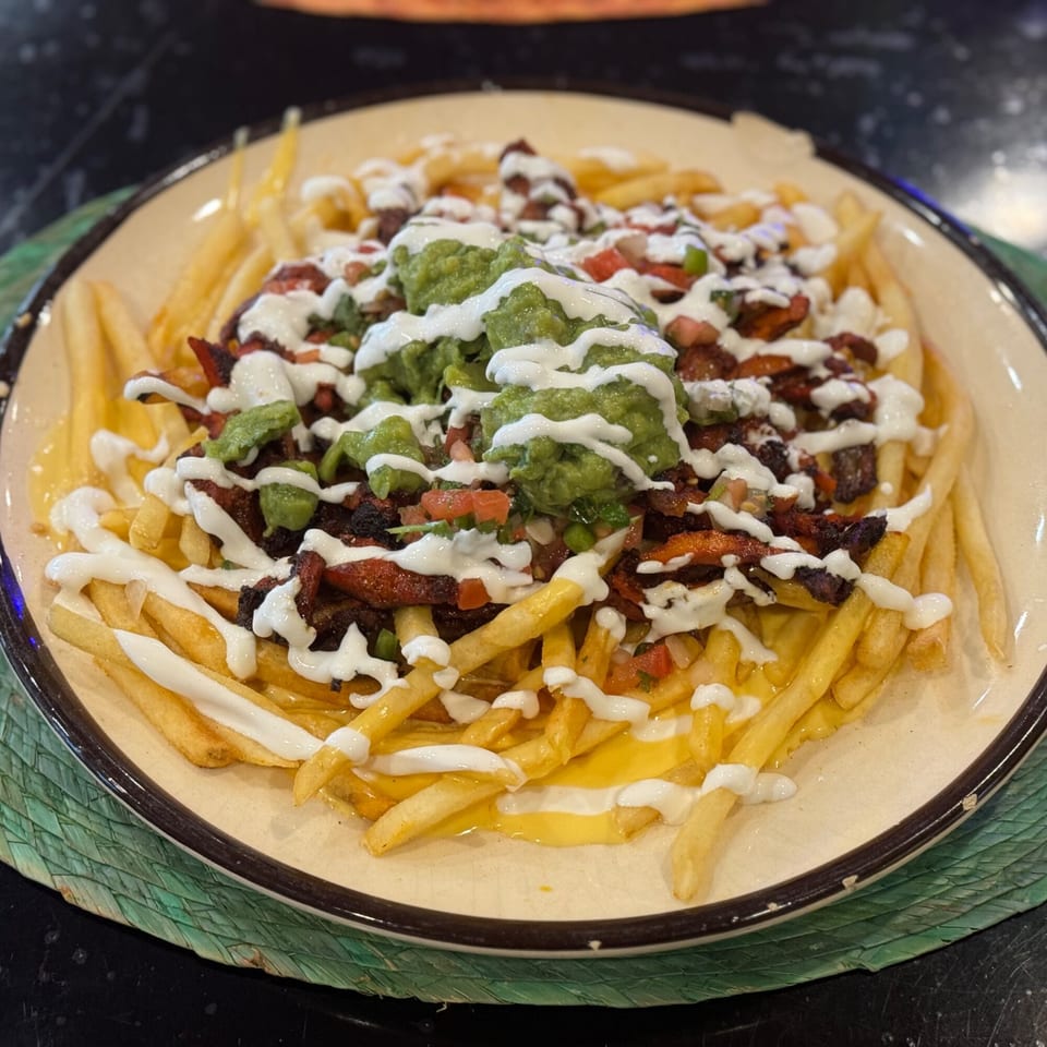 Loaded fries topped with guacamole, pico de gallo, sour cream, and carne asada.